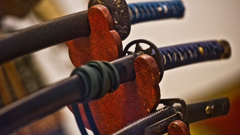 Samuraischwerter in einer Halterung (Symbolbild). Zwei Männer wollten sich in Tauberbischofsheim mit Samuraischwertern duellieren.