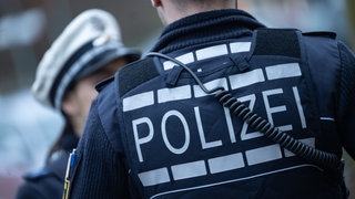 Symbolbild: Eine Polizistin und ein Polizist gehen eine Straße entlang. In Heilbronn gab es eine Großkontrolle in der Waffenverbotszone. Mehrere Messer wurden beschlagnahmt.