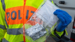Ein Polizeibeamter hält eine Tüte mit Kokain in der Hand (Symbolbil). Die Zahl der Kokain-Delikte hat sich in Heilbronn-Franken fast verdoppelt.