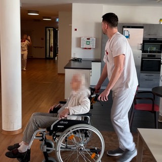 Die Bewohnerin eines Pflegeheims wird im Rollstuhl geschoben. Auch Menschen mit Demenz dürfen bei der Landtagswahl in Baden-Württemberg wählen.