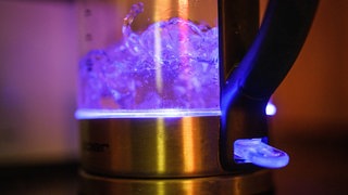 Wasser sprudelt in einem durchsichtigen Wasserkocher: In der Gemeinde Roigheim (Kreis Heilbronn) muss vorerst das Trinkwasser abgekocht werden - laut der Gemeindeverwaltung eine reine Vorsitsmaßnahme. (Symbolbild)