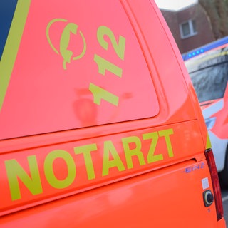 Ein Notarztfahrzeug und ein Rettungswagen steh vor einem Haus (Symbolbild). In Offenau (Kreis Heilbronn) ist ein Mann bei einem schweren Arbeitsunfall ums Leben gekommen.