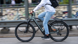 Ein Mann fährt auf einem E-Bike, der Hintergrund ist unscharf. (Symbolbild) In Heilbronn und Umgebung werden mehr E-Bikes verkauft. Das liegt laut einem Händler auch an steigenden Spritpreisen.