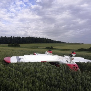 Ein kleines Propellerflugzeug liegt einem Getreidefeld auf dem Rücken. Das Ultraleichflugzeug hatte sich bei der Landung bei Möckmühl (Kreis Heilbronn) überschlagen.