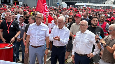 Die Oberbürgermeister von Neckarsulm, Steffen Hertwig (SPD), von Heilbronn, Harry Mergel (SPD) und der Heilbronner Landrat Norbert Heuser (parteilos) stehen in der ersten Reihe bei der Kundgebung am Audi-Werk Neckarsulm.