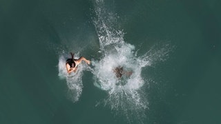 Menschen baden in einem Fluss (Symbol): Bei Wertheim haben zwei 16-Jährige zwei Jugendliche aus dem Main gerettet.