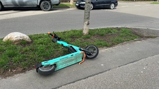 Ein E-Scooter liegt auf dem Gehweg (Symbolbild). 