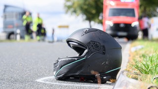 Der Helm eines Motorradfahrers liegt nach einem Unfall auf der Straße (Symbolbild).