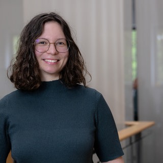 SWR-Reporterin steht in einem Großraumbüro