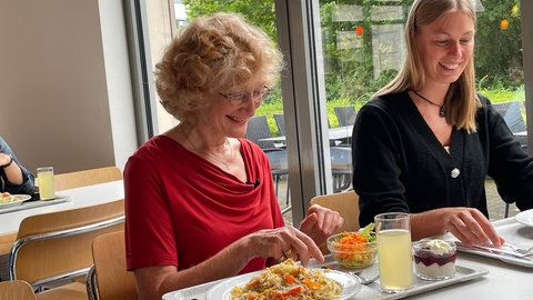 Studienteilnehmerin Petra Pojer sitzt an einem Tisch und isst. Bei einer groß angelegten Ernährungsstudie soll erforscht werden, wie gesund vegane Ernährung ist.