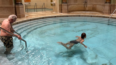Zwei Badende mit Badekleidung im großen Becken des Friedrichsbads