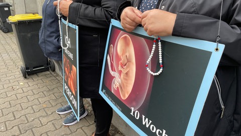 Schilder, mit denen Abtreibungsgegner vor Pro Familia in Pforzheim gegen Abtreibungen protestieren.