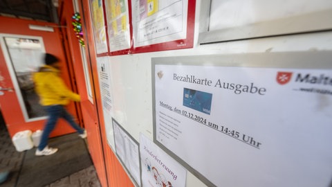 Ein Schild weist in der Erstaufnahmeeinrichtung Eggenstein-Leopoldshafen (Landkreis Karlsruhe) auf die Ausgabe von Bezahlkarten hin. 
