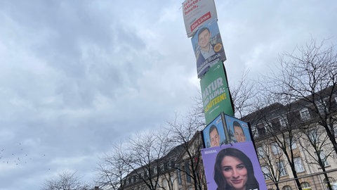 Mehrer Wahlplakate von verschiedenen Parteien hängen an einer Laterne