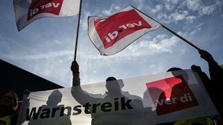Streikende schwenken ver.di-Fahnen beim Warnstreik im öffentlichen Dienst.