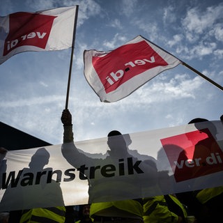 Streikende schwenken ver.di-Fahnen beim Warnstreik im öffentlichen Dienst.