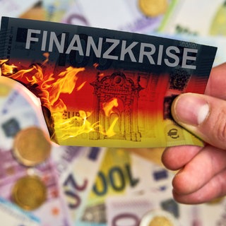 Brennende Geldscheine mit Aufschrift "Haushaltsloch"