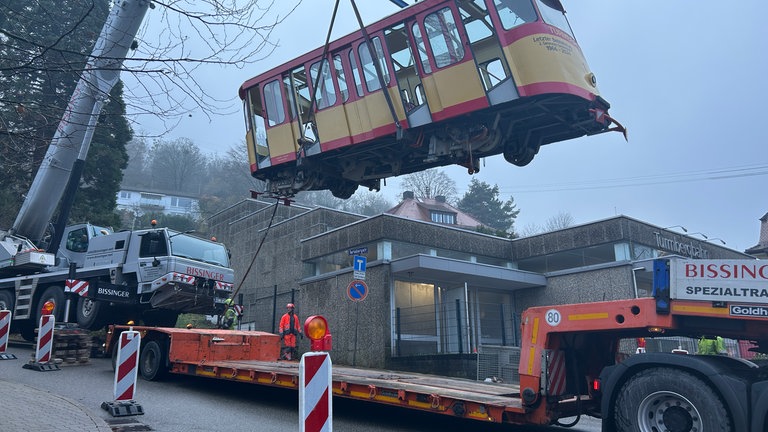 Ein Wagen der Turmbergbahn in Karlsruhe-Durlach wird von einem Kran aus den Schienen gehoben und abtransportiert.