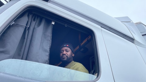 Adam M., Lkw-Fahrer aus Simbabwe, sitzt in seinem Führerhaus. Er demonstriert seit Tagen in Karlsruhe gegen seinen Arbeitgeber.