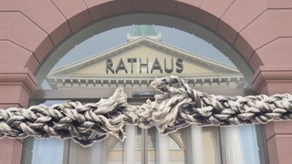 Zum Zerreissen gespanntes Seil vor dem Karlsruher Rathaus. Wegen der Finanzkrise sind die World Games 2029 in Karlsruhe eine Zerreißprobe.