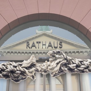 Zum Zerreissen gespanntes Seil vor dem Karlsruher Rathaus. Wegen der Finanzkrise sind die World Games 2029 in Karlsruhe eine Zerreißprobe.