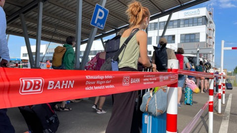 Reisende am Bahnhof in Baden-Baden stehen Schlange, um mit dem Schienenersatzverkehr weiterzufahren. (Symbolbild)
