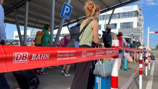 Reisende am Bahnhof in Baden-Baden stehen Schlange, um mit dem Schienenersatzverkehr weiterzufahren. (Symbolbild)