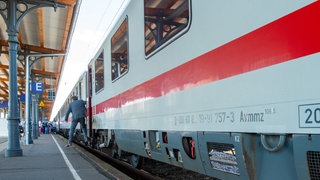 Ein Bahnreisender steigt an einem Bahnhof aus einem Intercity aus