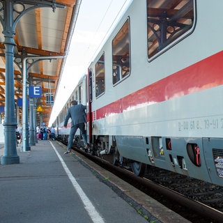 Ein Bahnreisender steigt an einem Bahnhof aus einem Intercity aus