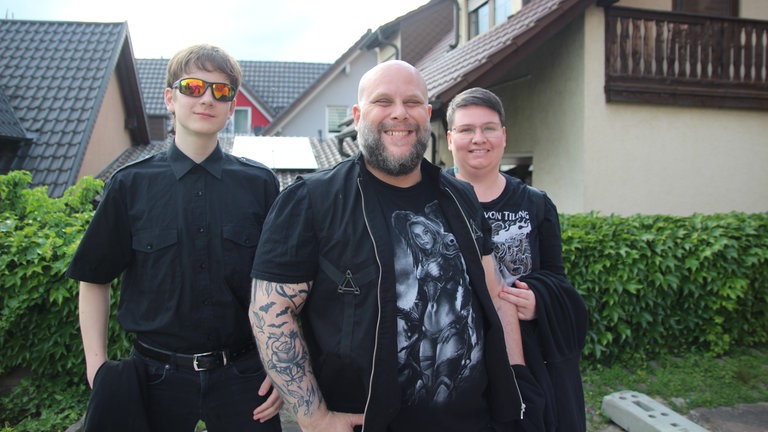 (v. r. n. l.): Marcus Dietrich, Holger Dietrich und Christin vor dem Headbanger Gottesdienst auf dem Platz vor der Kirche in Bruchsal-Obergrombach.