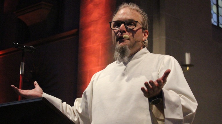 Pastoralreferent Mathias Fuchs bei der Predigt des Headbanger Gottesdienstes in Bruchsal-Obergrombach.