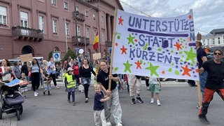 Eltern demonstrieren mit ihren Kindern in Karlsruhe gegen die Streichung des Kita-Rabatts für Geschwister