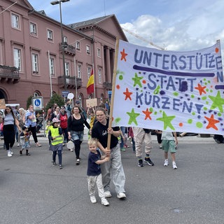 Eltern demonstrieren mit ihren Kindern in Karlsruhe gegen die Streichung des Kita-Rabatts für Geschwister