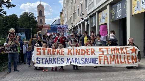 Eltern demonstrieren mit ihren Kindern in der Innenstadt von Karlsruhe