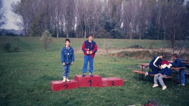 Zwei Jungen auf einem Siegertreppchen nach einem Sportwettkampf für Kanuten in den 80er-Jahren.
