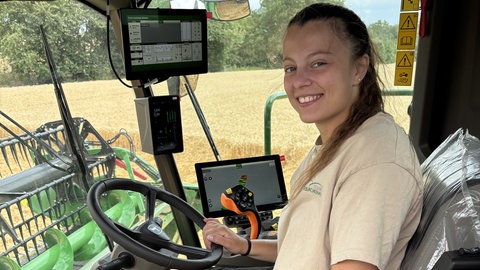 Anna Dahm sitzt in Bruchsal am Steuer eines Mähdreschers. Sie will in Zukunft in der Landwirtschaft noch mehr KI nutzen.