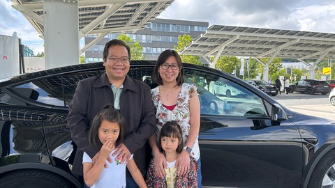 Familie steht vor ihrem E-Auto in Pforzheim an der Ladesäule