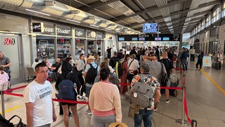 Symbolbild: Passagiere warten am Flughafen Karlsruhe Baden-Baden vor der Sicherheitskontrolle