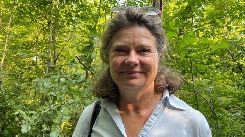 Eine Frau lächelt in die Kamera. 
