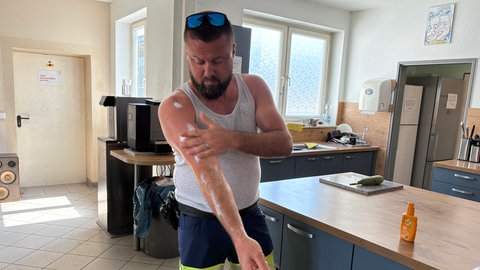 Tobias Leppert cremt sich vor seiner Schicht am Flughafen KarlsruheBaden-Baden mit Sonnencreme ein.