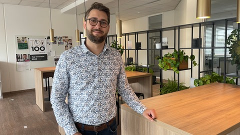 Ein Mann mit Brille lächelt in die Kamera.
