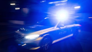 Verfolgungsfahrt mit Polizeiauto und Blaulicht bei Dunkelheit