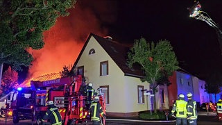 Einsatzkräfte der Feuerwehr bei einem Brand in Eggenstein-Leopoldshafen (Kreis Karlsruhe). In der Nacht auf Donnerstag hat ein Feuer eine Scheune und ein Wohngebäude erfasst.