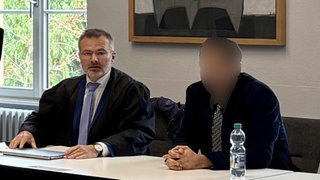 Der Verteidiger und ein radikaler Prediger aus Pforzheim, der in Karlsruhe vor Gericht stand, im Gerichtssaal.