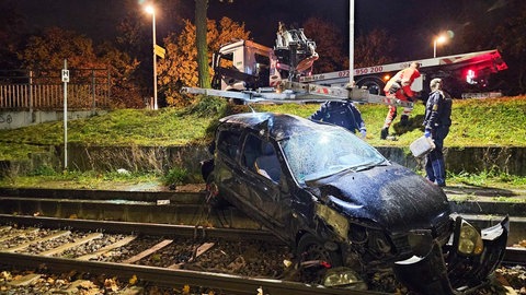 Unfall in Karlsruhe. Auto hat sich überschlagen und landet in Gleisbett. Kran soll Wagen bergen.