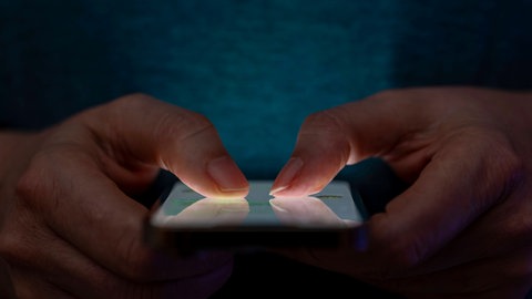 Symbolbild: Jemand hält ein Smartphone in der Hand. Immer mehr Erwachsene sind von Mobbing oder Cybermobbing betroffen.