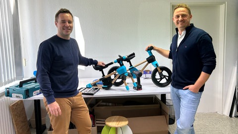 Die Gründer der Firma FxB Engineering Frank Bielecke (links) und Norbert Fischer (rechts) zeigen ein selbstentwickeltes Laufrad aus Holz.