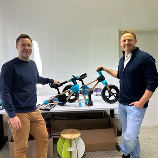 Die Gründer der Firma FxB Engineering Frank Bielecke (links) und Norbert Fischer (rechts) zeigen ein selbstentwickeltes Laufrad aus Holz.