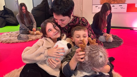 Mathilda, Julius und ihre Mutter im Elektronischen Streichelzoo mit KI-Robotern im ZKM.