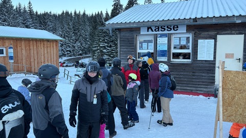 Skifahrende stehen Schlange vor der Kasse der Skipiste Mehliskopf.